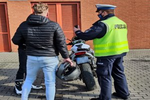 Policjant kontroluje motocyklistę