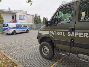 pojazd patrolu saperskiego i policji przed budynkiem szkoły